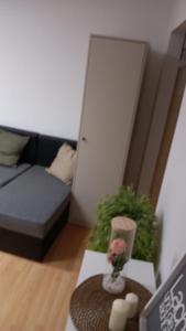 sala de estar con sofá y jarrón con planta en SleepWellCologne en Colonia