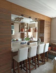 Agréable appartement في الرباط: مطبخ وكراسي بيضاء وجزيرة مطبخ