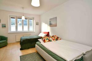 a bedroom with two beds and a couch and a window at Cozy 2BR in heart of old town in Bratislava