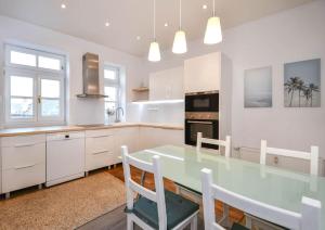 a kitchen with a glass table and white cabinets at Cozy 2BR in heart of old town in Bratislava