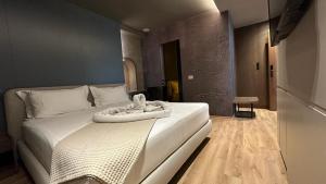 Un dormitorio con una cama blanca con una toalla. en Hani i Gjelit Hotel, Korce en Korçë
