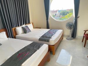 2 camas en una habitación con ventana y ventilador en Sen's Homestay en Ninh Binh
