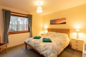 a bedroom with a bed with two green pillows on it at Aonach in Kingussie