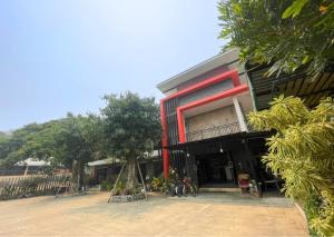 a building with a red stripe on the side of it at Smaids Room in Lampang
