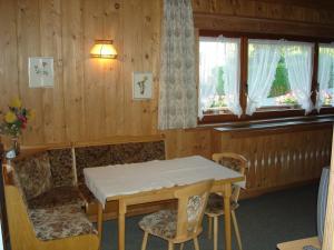 a dining room with a table and chairs and windows at Landhaus Brigitta in Innsbruck