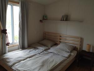 uma cama num quarto com uma janela em ביתהבוצ - מקום טבעי למפגשים em Talmei Yosef