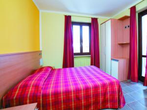 a bedroom with a bed with a pink plaid blanket at Residenza Gildo in Frabosa Soprana