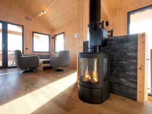 a fireplace in the middle of a room with chairs at Lovely Chalet in Turracherh he with Sauna in Turracher Hohe