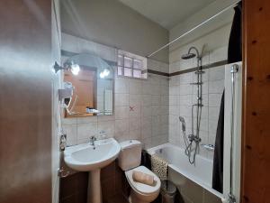 uma casa de banho com um lavatório, um WC e uma banheira em Skourgias Rooms em Kala Nera