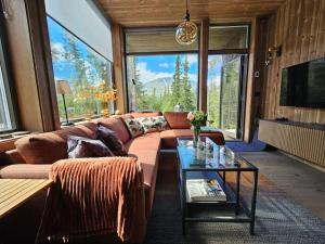 リューカンにあるFin leilighet med flott utsikt til Gaustatoppenのソファとテーブルのあるリビングルーム