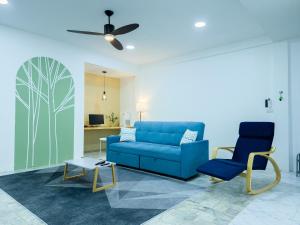 een woonkamer met een blauwe bank en een stoel bij Eco-friendly house near street food quiet area in Chiang Mai