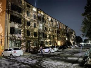 a row of cars parked in front of a building at Aleksandra Apartment in Samarkand