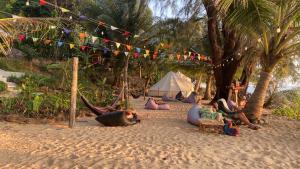 a group of people laying in hammocks on the beach at Robinson Bungalows in Koh Rong Sanloem