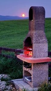 un horno de piedra con la puesta de sol en el fondo en Trzy Szczyty-Wysoka, en Grywałd