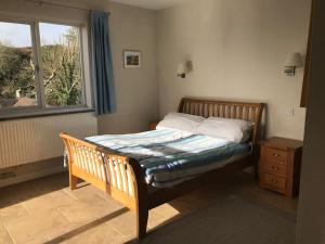 a bedroom with a bed with a window and a wooden bed frame at West Winds in Oxwich