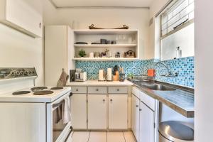 a kitchen with white cabinets and blue tiles at Trendy 1 bedroom flat in the heart of Green Point in Cape Town