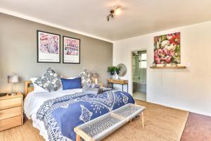 een slaapkamer met een bed met een blauwe en witte sprei bij Trendy 1 bedroom flat in the heart of Green Point in Kaapstad