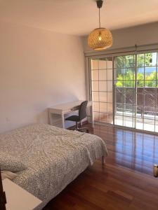 a bedroom with a bed and a desk and a window at Xanadu Coliving in Santa Úrsula
