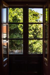 una ventana abierta con vistas a un árbol en hostal Nomade Santiago, en Santiago de Compostela