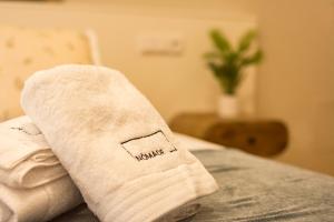 a white towel sitting on top of a bed at hostal Nomade Santiago in Santiago de Compostela