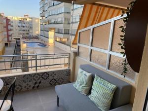 een balkon met een bank en uitzicht op een gebouw bij Estudio Primera línea de Playa in Tavernes de la Valldigna