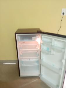 an empty refrigerator with its door open in a room at The Grace Guest House in Salcete