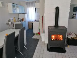 a stove in a room with a table and a kitchen at Kuća za odmor Dunavski raj in Batina