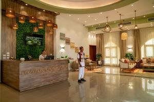 アブ・シンベルにあるAzal Lagoons Resort Abu Simbelのホテルロビーのカウンターに立つ男