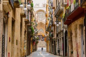 an alleyway between two buildings with a person walking down it at Oh La Lá in Tarragona +13 photos