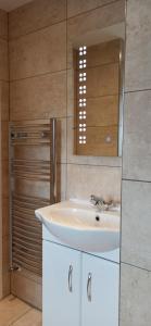 une salle de bains avec un lavabo blanc et un miroir dans l'établissement Broxtowe house -3 bed House parking Nottingham, à Nottingham 19 autres photos
