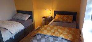 une chambre avec deux lits et une lampe sur une table dans l'établissement Broxtowe house -3 bed House parking Nottingham, à Nottingham