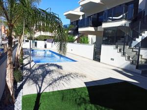 a villa with a swimming pool in front of a building at Mar Menor Elisa Apartment in Santiago de la Ribera