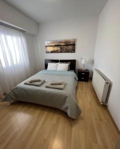 1 dormitorio con 1 cama con 2 toallas en Daniela's modern apartment, en Strovolos