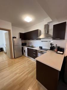 cocina con electrodomésticos de acero inoxidable y suelo de madera en Daniela's modern apartment, en Strovolos