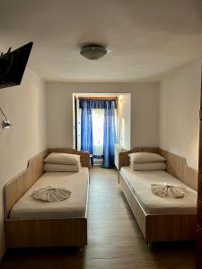 Cette chambre comprend 2 lits et une fenêtre. dans l'établissement Casa Andra, à Baia de Fier