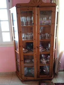 a wooden cabinet filled with glasses and dishes at Mar de flores in Vega de San Mateo