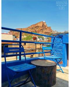 two chairs sitting on a balcony with a view of the mountain at Raj Mandir Boutique Home Stay in Jodhpur
