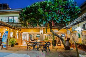 patio ze stołem, krzesłami i drzewem w obiekcie S Lodge Pattaya formally Sabai Lodge w mieście Pattaya Central