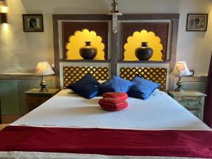 a bedroom with a bed with blue and red pillows at Raj Mandir Boutique Home Stay in Jodhpur