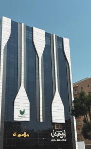 Un edificio con dos jarrones altos pintados en él. en Glamour Inn AL Nuzha -جلامور ان النزهة, en Yeda