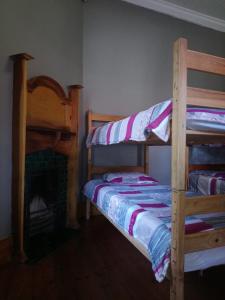 2 literas en una habitación con chimenea en Hostel Villa Nova, en Mossel Bay