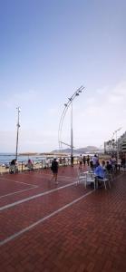 een groep mensen die in stoelen op het strand zitten bij Paraíso playero en Las Palmas in Las Palmas de Gran Canaria