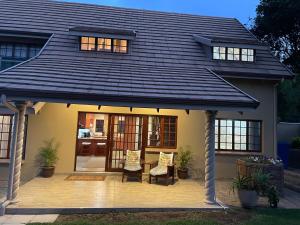 a house with a wooden deck with a roof at OAK HOUSE, Entire holiday home, Self catering, fully equipped, double storey, 3 bedroom, 2 bathroom, outside entertainment, Braai area, 300sqm home in Hillcrest