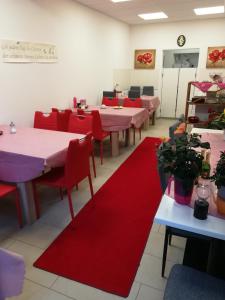 蘭根堡的住宿－Gaestehaus Jagsttalblick，一间设有桌子、红色椅子和红色垫子的用餐室
