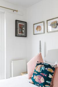 un letto con cuscino rosa e foto appese al muro di Trendy Central 1 Bed Flat with Roof Terrace a Brighton & Hove