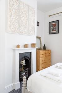 a bedroom with a fireplace and a bed and a dresser at Trendy Central 1 Bed Flat with Roof Terrace in Brighton & Hove