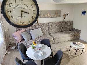 a living room with a large clock on the wall at Apartment Dalyce in Šiauliai