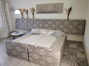 a bedroom with a bed with a padded headboard at Apartment Dalyce in Šiauliai