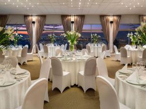 a banquet room with white tables and white chairs at Hotel des Mille Collines in Kigali +27 photos