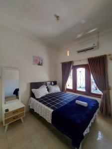 ein Schlafzimmer mit einem blauen Bett und einem Fenster in der Unterkunft FAZILA homestay in Yogyakarta